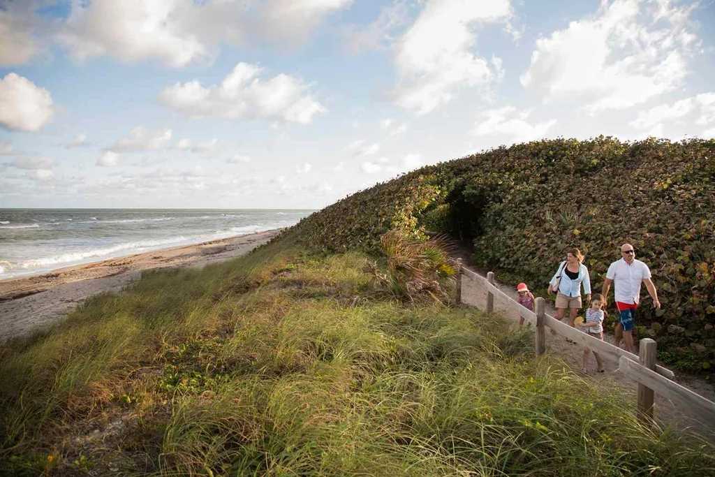 Family walking on coastal path, Blowing Rocks Preserve