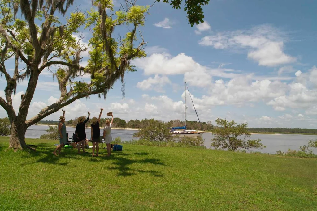 Women waving to a sailboat in Washington Oaks Gardens