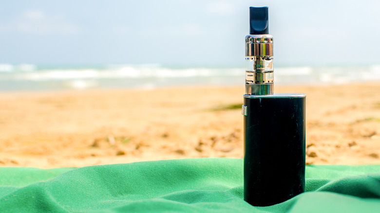Une cigarette électronique posée sur une plage