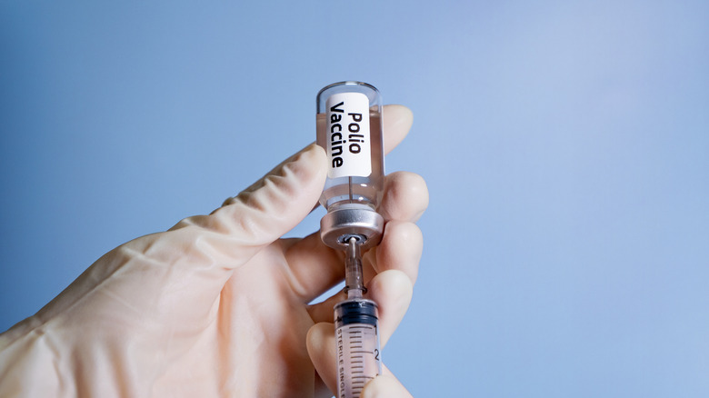 Main tenant un flacon de vaccin contre la polio