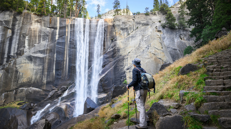 Une randonneuse observant une cascade à Yosemite