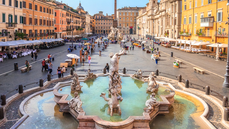 Fontaine et foule sur une place italienne