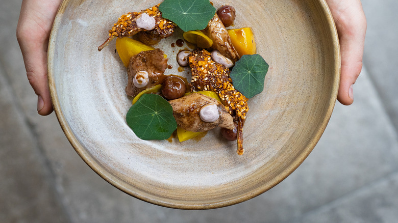 Vue aérienne d'un plat gastronomique porté par un chef