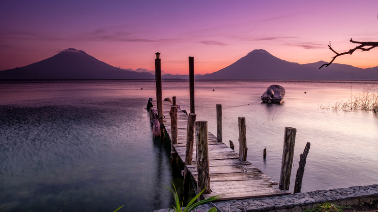 Un ponton sur le lac Atitlán avec des volcans en arrière-plan au lever du soleil
