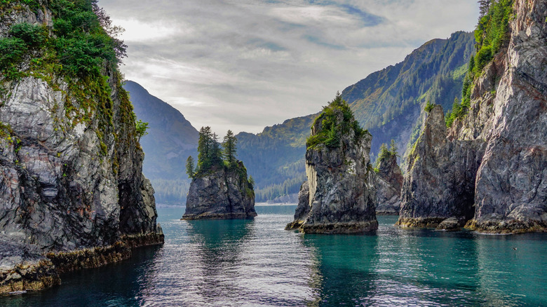 formations rocheuses dans une baie océanique avec des montagnes au loin
