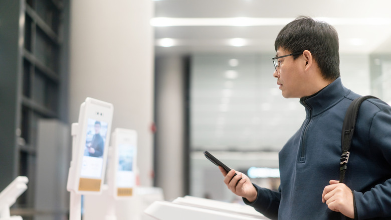 Homme utilisant la reconnaissance faciale pour l'embarquement