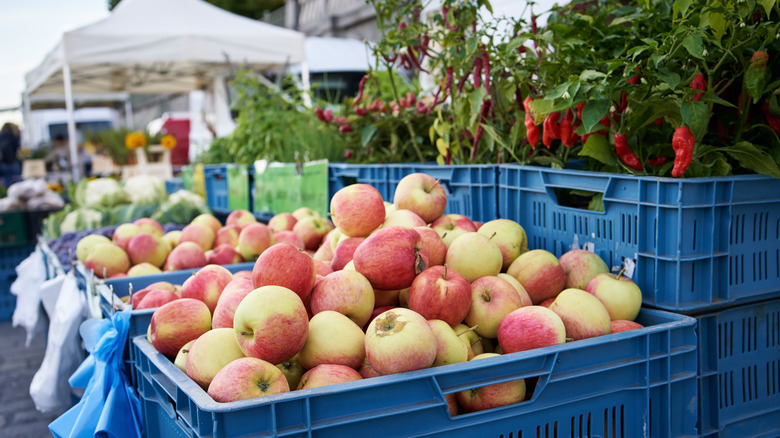Caisses de pommes et de poivrons sur un marché en plein air