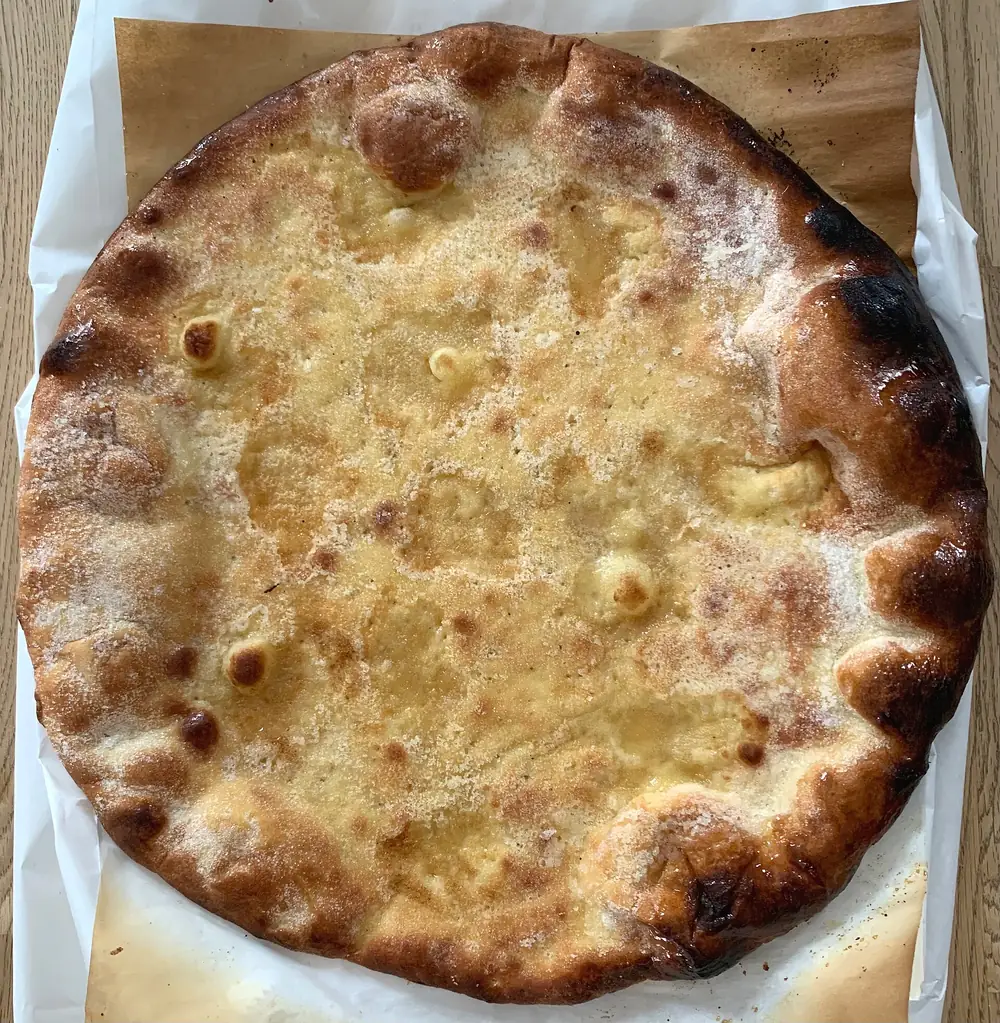 Une galette de Pérouges bien dorée, posée sur son papier.