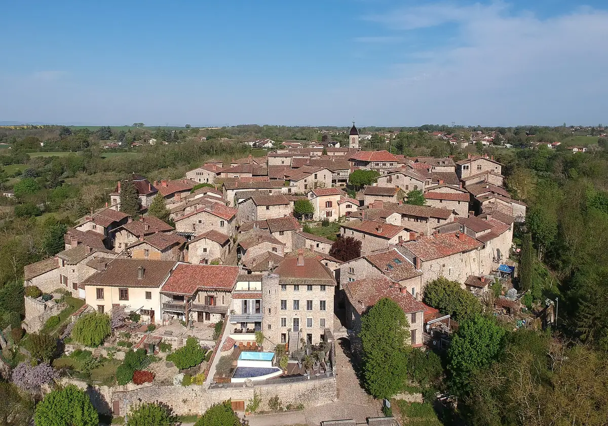 Vue aérienne de la cité médiévale de Pérouges et de ses toits de tuiles, au milieu de la verdure de l'Ain.
